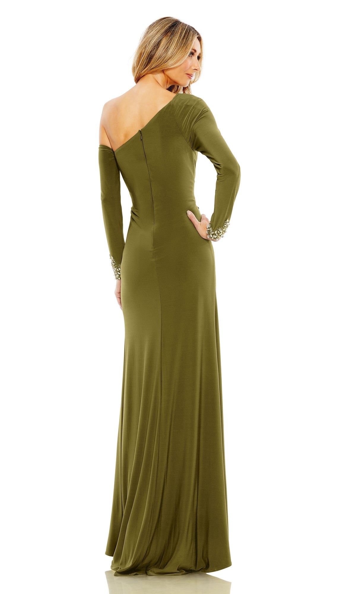 A woman stands facing away from the camera, wearing the Mac Duggal Long Formal Dress 12489—an olive green, long-sleeved gown with one shoulder exposed.